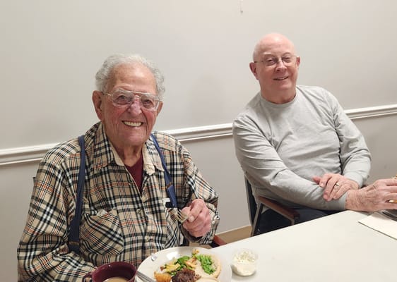 Two smiling residents enjoying a meal together