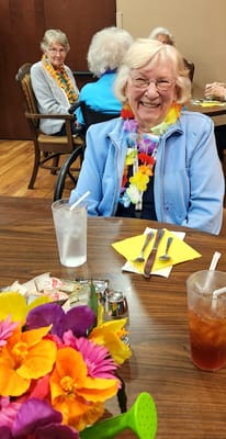 Resident enjoying a festive meal with flowers and drinks