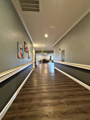 Long hallway with artwork and seating area visible
