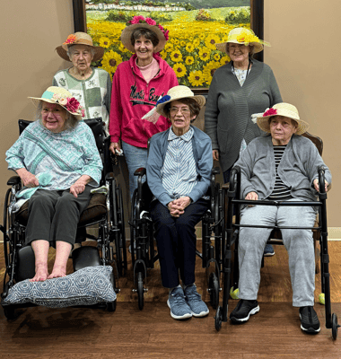 Residents with hats smiling in a common area