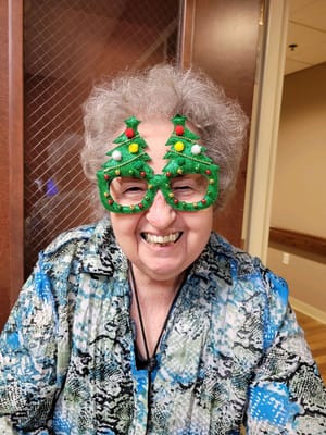 Resident wearing festive glasses with holiday decorations