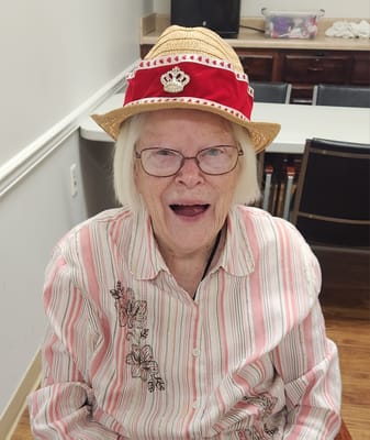 Resident smiling in a festive hat during an activity