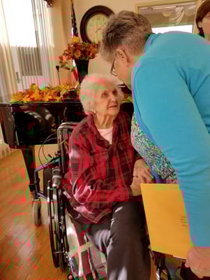 A caregiver interacting with a resident in a bright common area