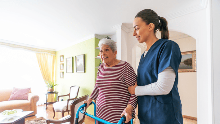 Caregiver assisting a senior resident in an interior setting