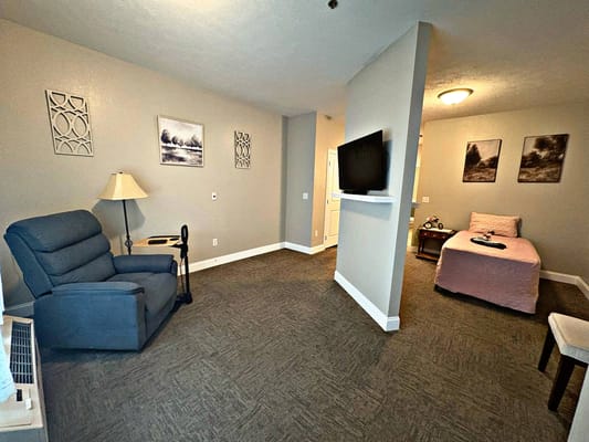 Cozy and well-furnished resident room with a bed and chair