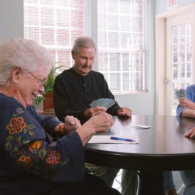 Seniors playing cards in a common area
