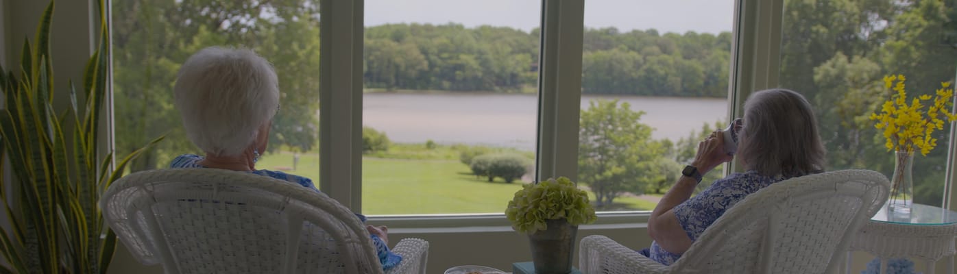Two residents enjoying the lakeside view indoors