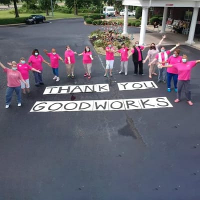 Staff and residents expressing gratitude with a large sign