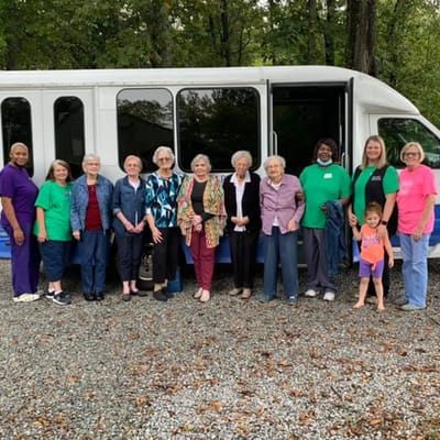Group of people gathered by a facility transport bus