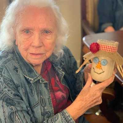 Senior resident holding a decorated craft