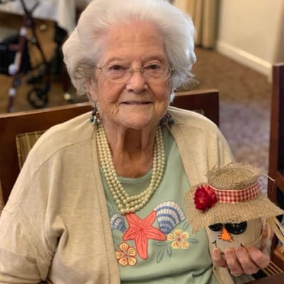 Resident proudly holding a decorated flower pot