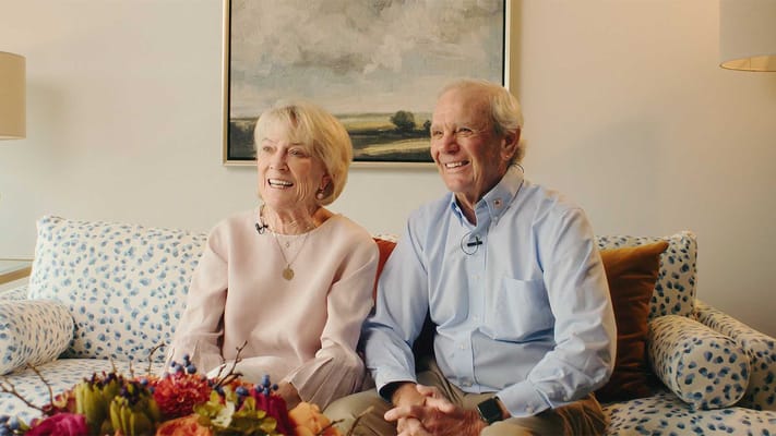 Two residents smiling in a cozy living room setting