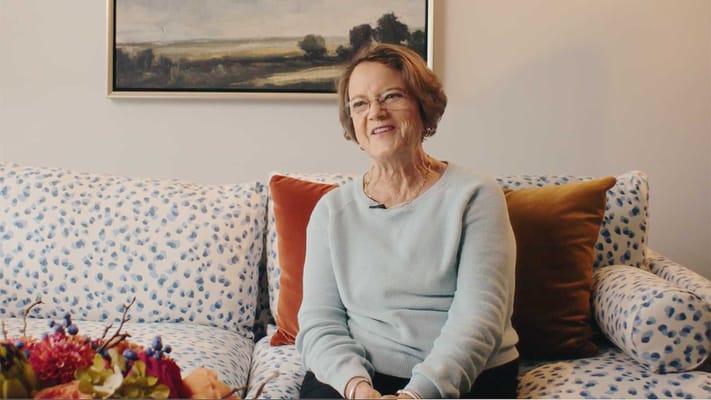 Resident smiling on a comfortable couch in the facility