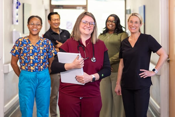 Staff members posing in a facility hallway