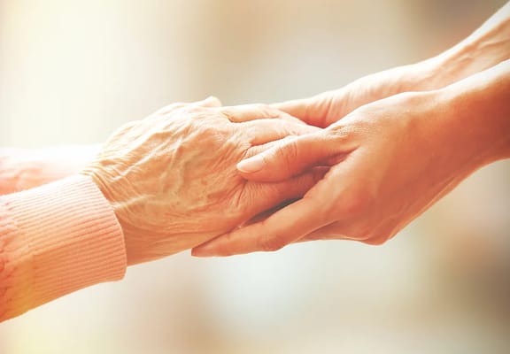 Two hands clasped together, symbolizing care and support