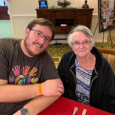A resident and staff member sharing a meal together