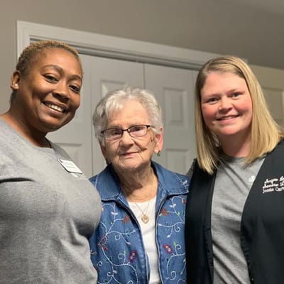 Two staff members smiling with a resident