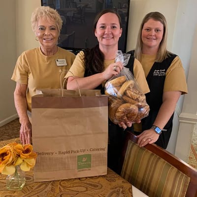 Staff members with a food delivery bag and pastries