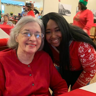 A resident and staff member smiling together during a celebration