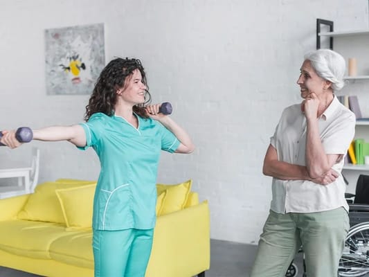 Staff assisting a resident with weights in a bright room