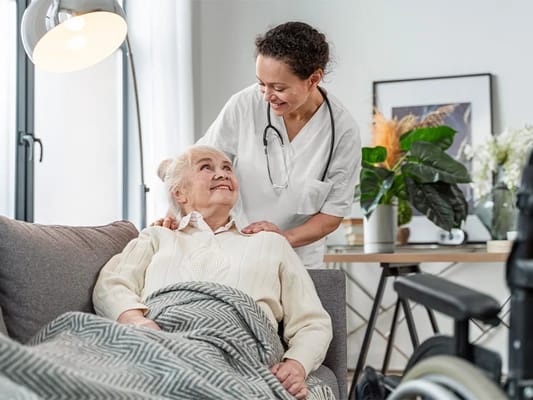 Caregiver assisting a senior resident in a cozy living space