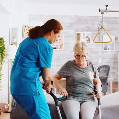 Caregiver assisting a resident in a bright interior space