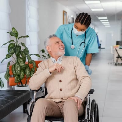 A caregiver assists a resident in a bright hallway