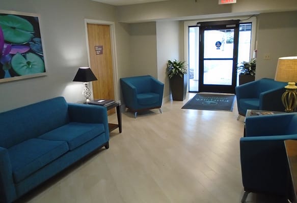 Bright common area with teal furniture and plants