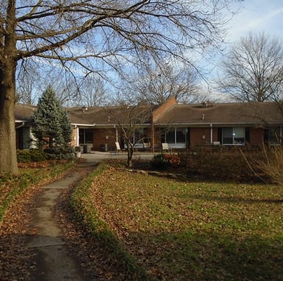 Pathway leading to a senior living exterior with gardens