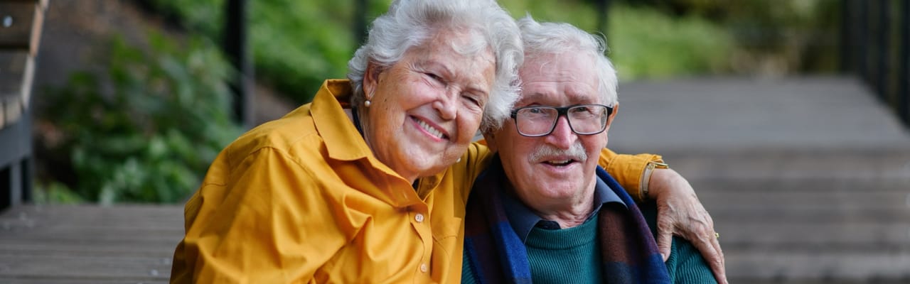 Two smiling residents sitting together outdoors