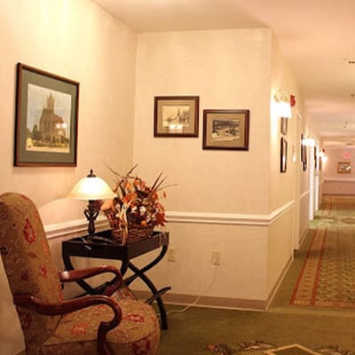 Interior hallway with framed pictures and a decorative chair