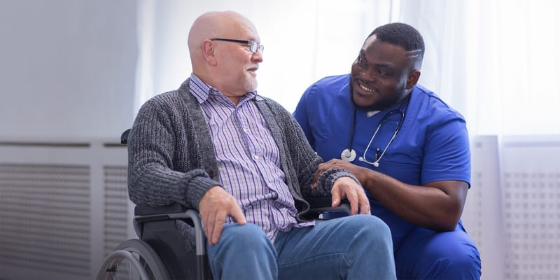 A caregiver interacting with a resident in a bright room
