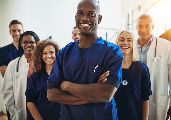 Group of smiling healthcare staff in scrubs