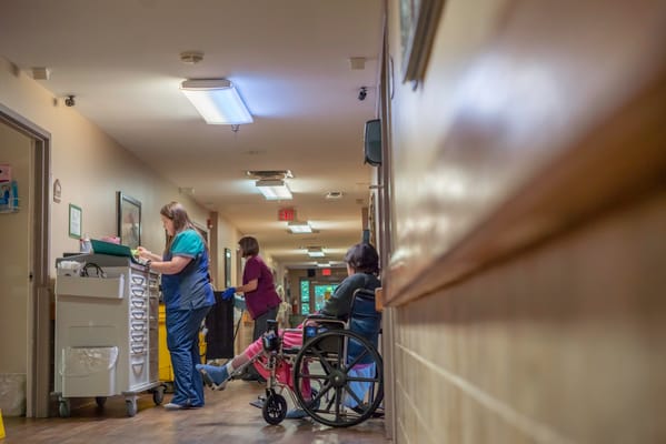 Staff assisting residents in a hallway