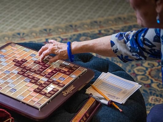 A close-up of a resident playing Scrabble