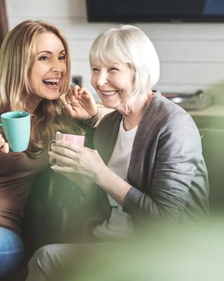 Two women sharing a joyful moment with coffee