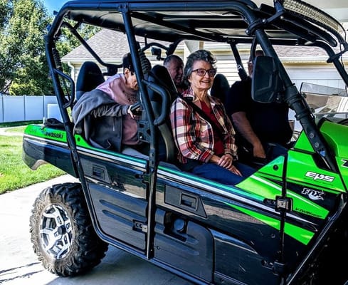 Residents enjoying a ride in a green utility vehicle