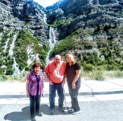 Residents and staff outdoors with a waterfall backdrop