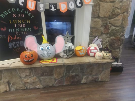 Decorated pumpkins on a stone fireplace mantle