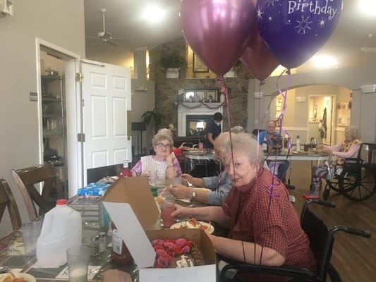 Residents celebrating a birthday with balloons and food