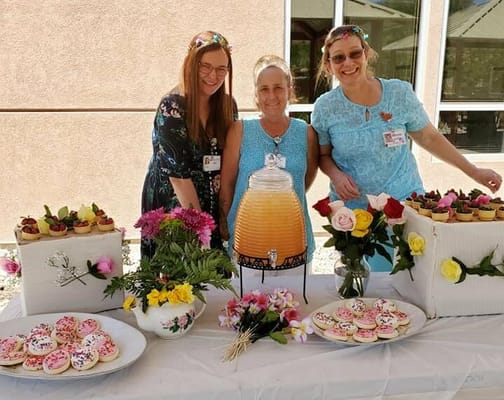 Staff celebrating with treats and flowers outside