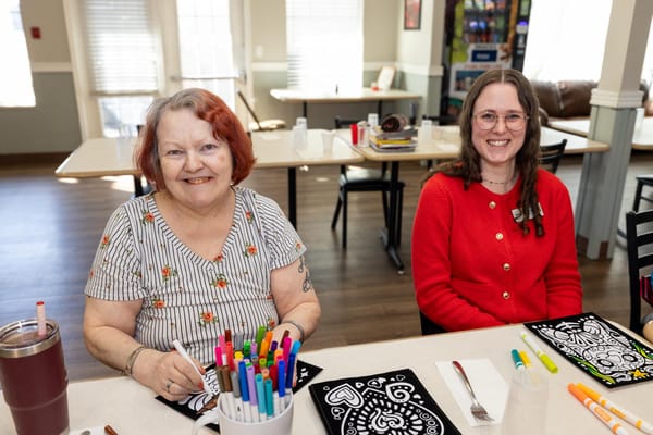 Residents enjoying an arts and crafts activity in a sunny communal space