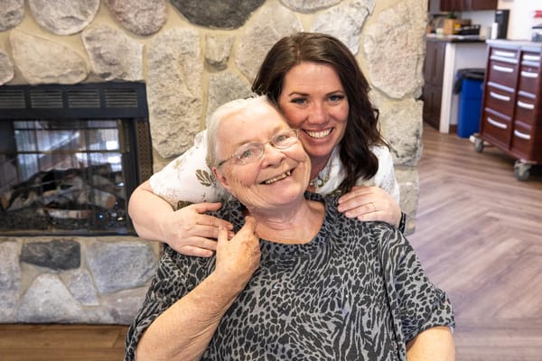 Resident enjoying time with staff member in a cozy common area