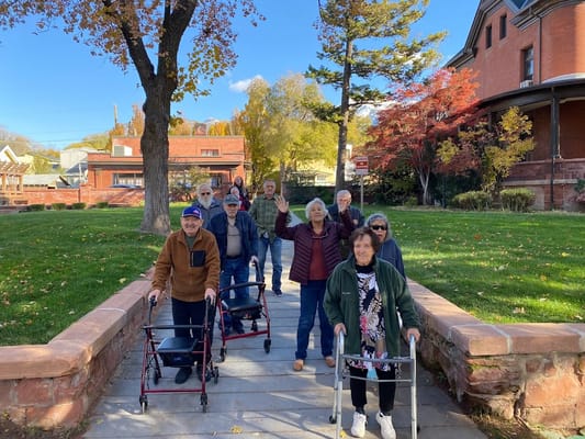 Residents walking outdoors with walkers on a sunny day