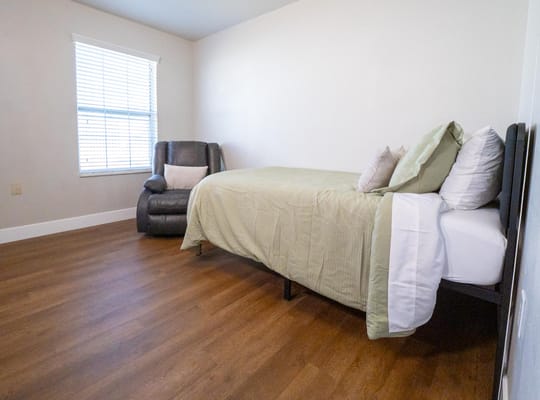 Private resident room with bed and chair