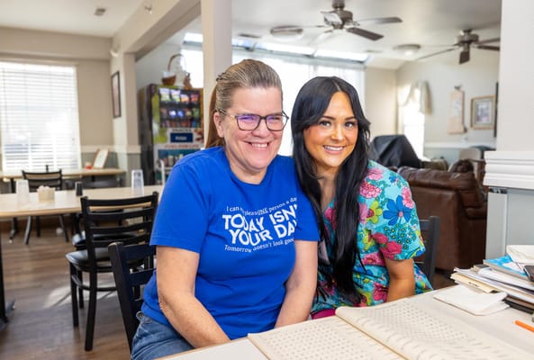 Staff and resident smiling together in a common area