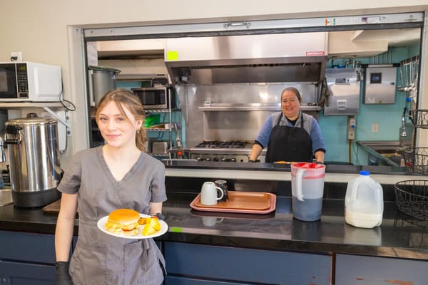Staff member serving food in the kitchen area