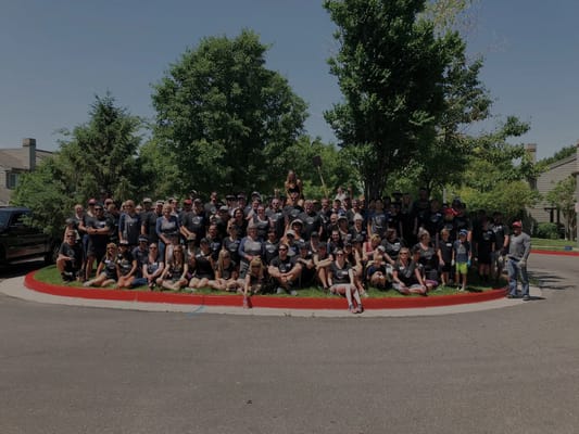 Large group photo of staff and families outside