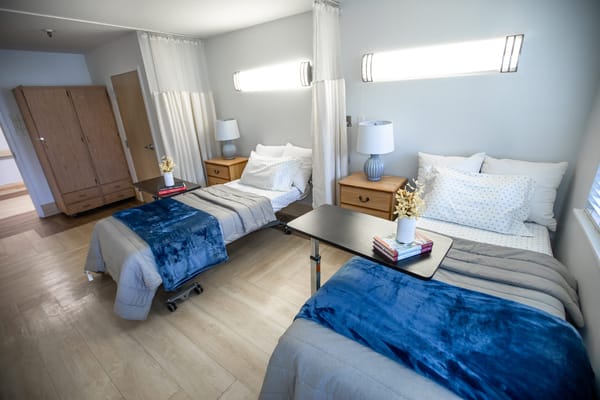 Bright shared bedroom with two beds and lamps