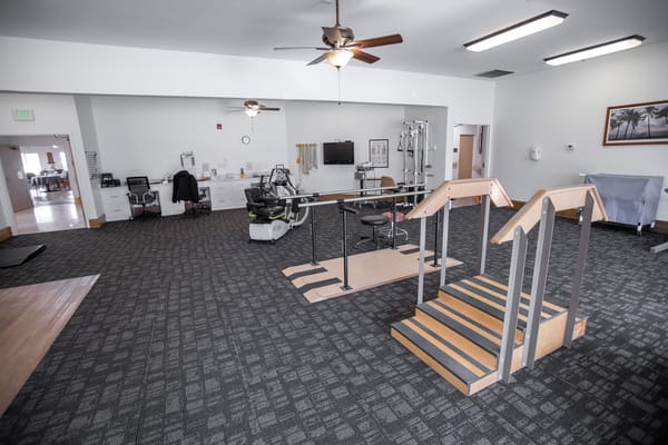 Rehabilitation gym area with equipment and stairs